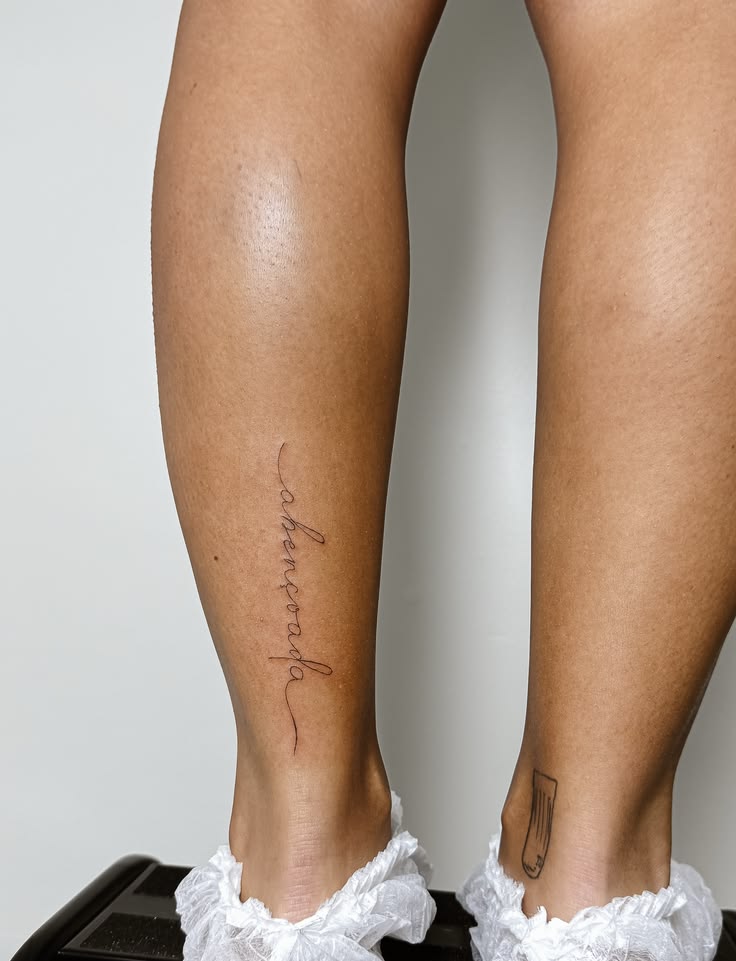 Mulher tatuadora mostrando lugar da tatuagem fineline no braço de cliente em Sertãozinho